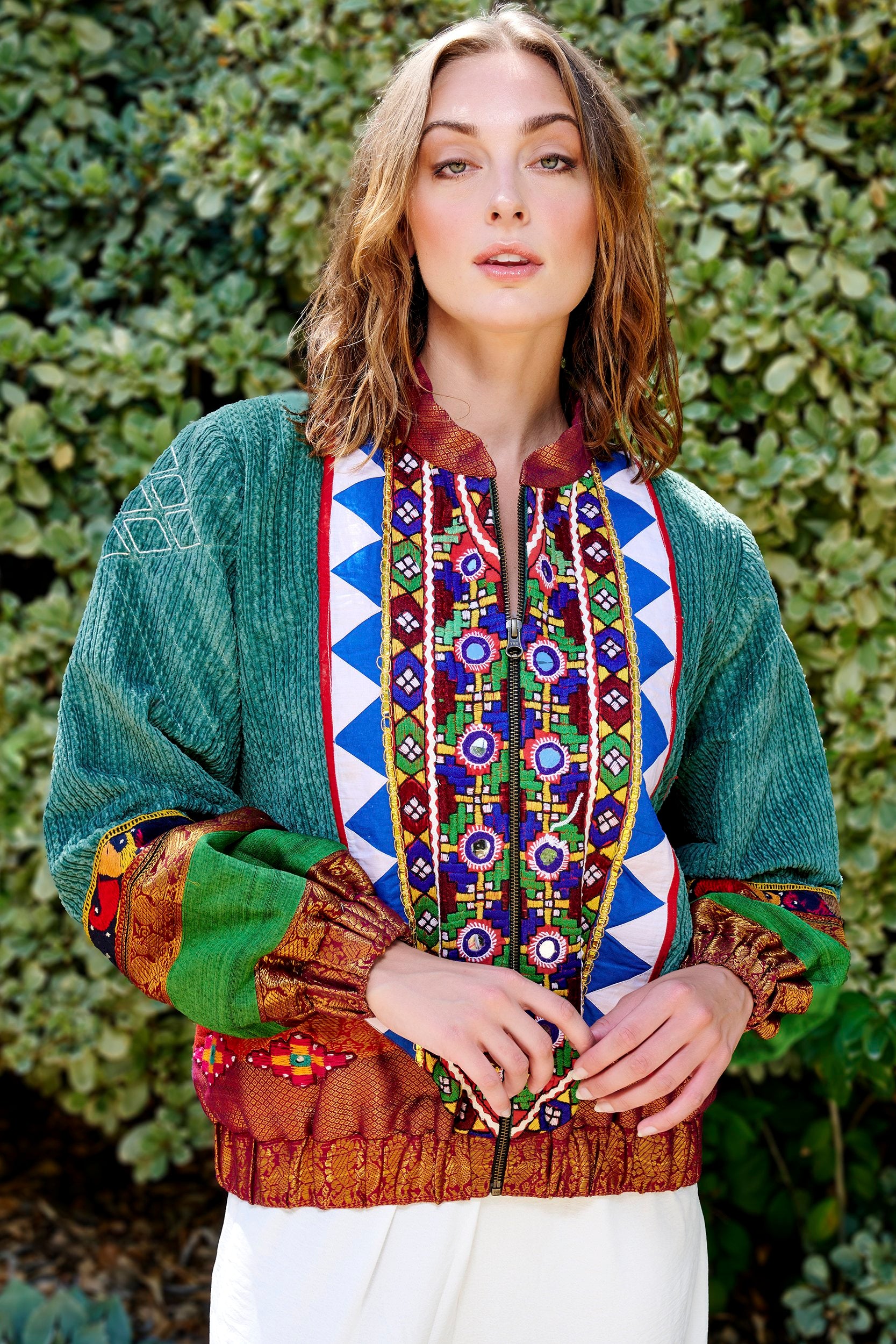 Model wearing a green bomber jacket with mirrored patchwork design.A perfect blend of style and sustainability in fashion.