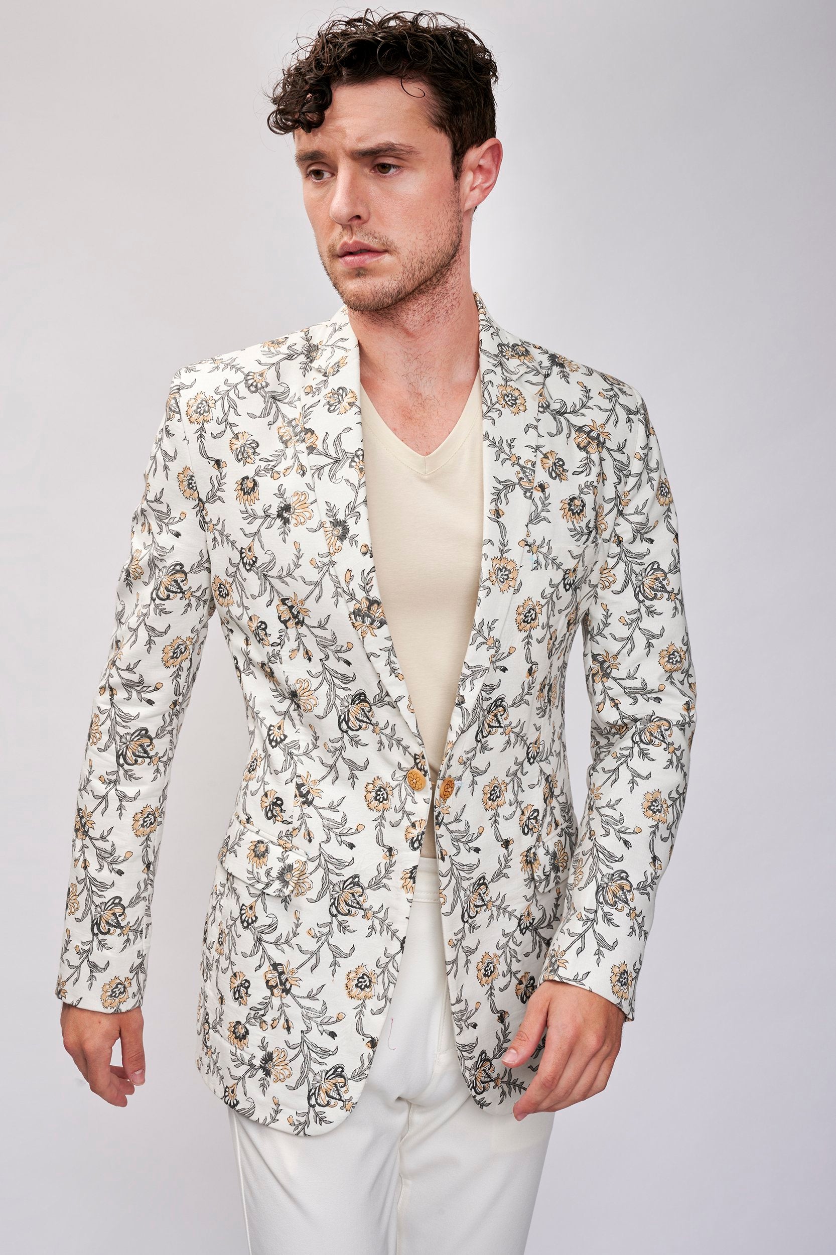 Model wearing a white hand block printed floral blazer made with organic cotton. A perfect blend of style and sustainability in fashion.