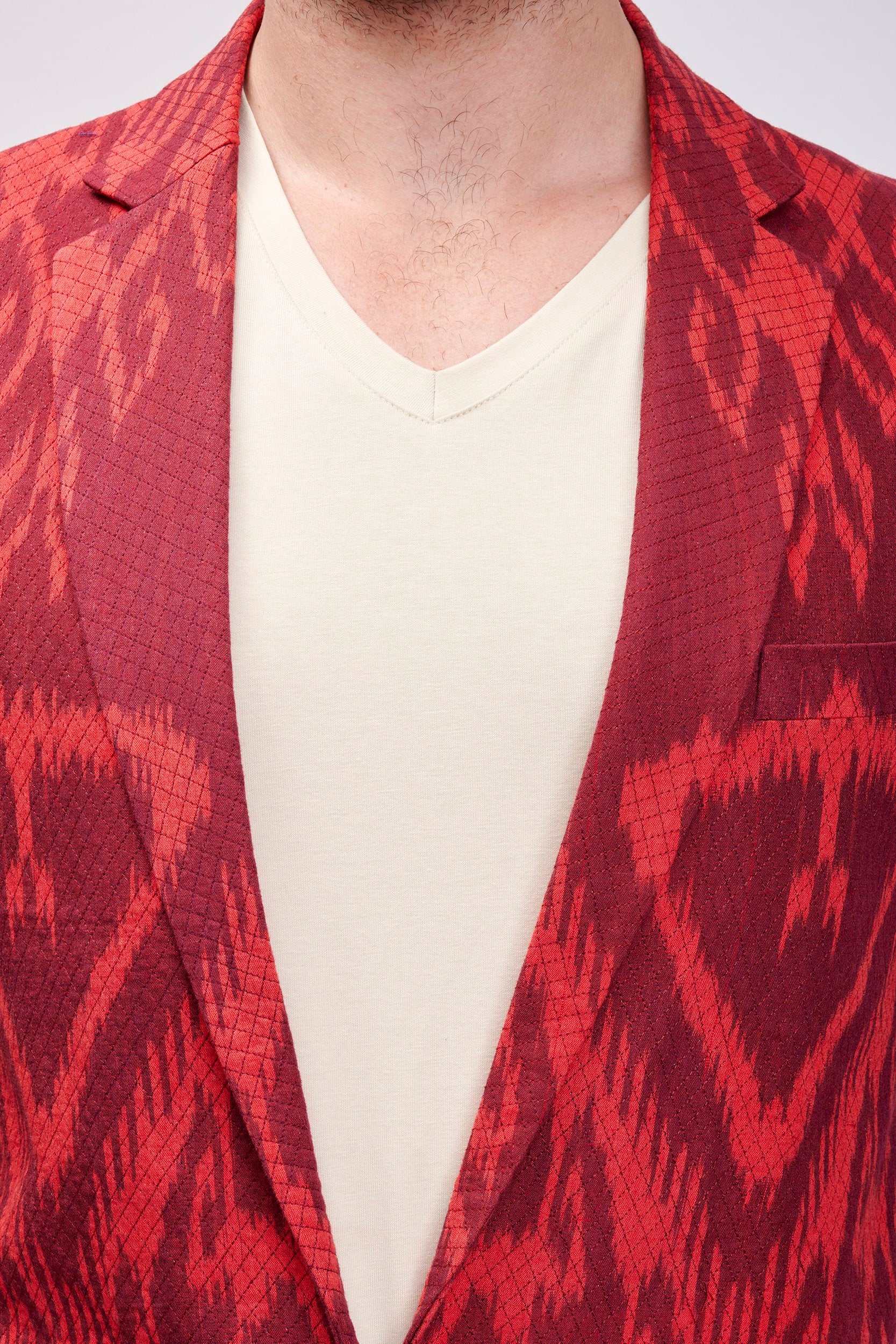 Closeup shot of a crimson blazer showing cross stitch lines on the surface of the blazer.