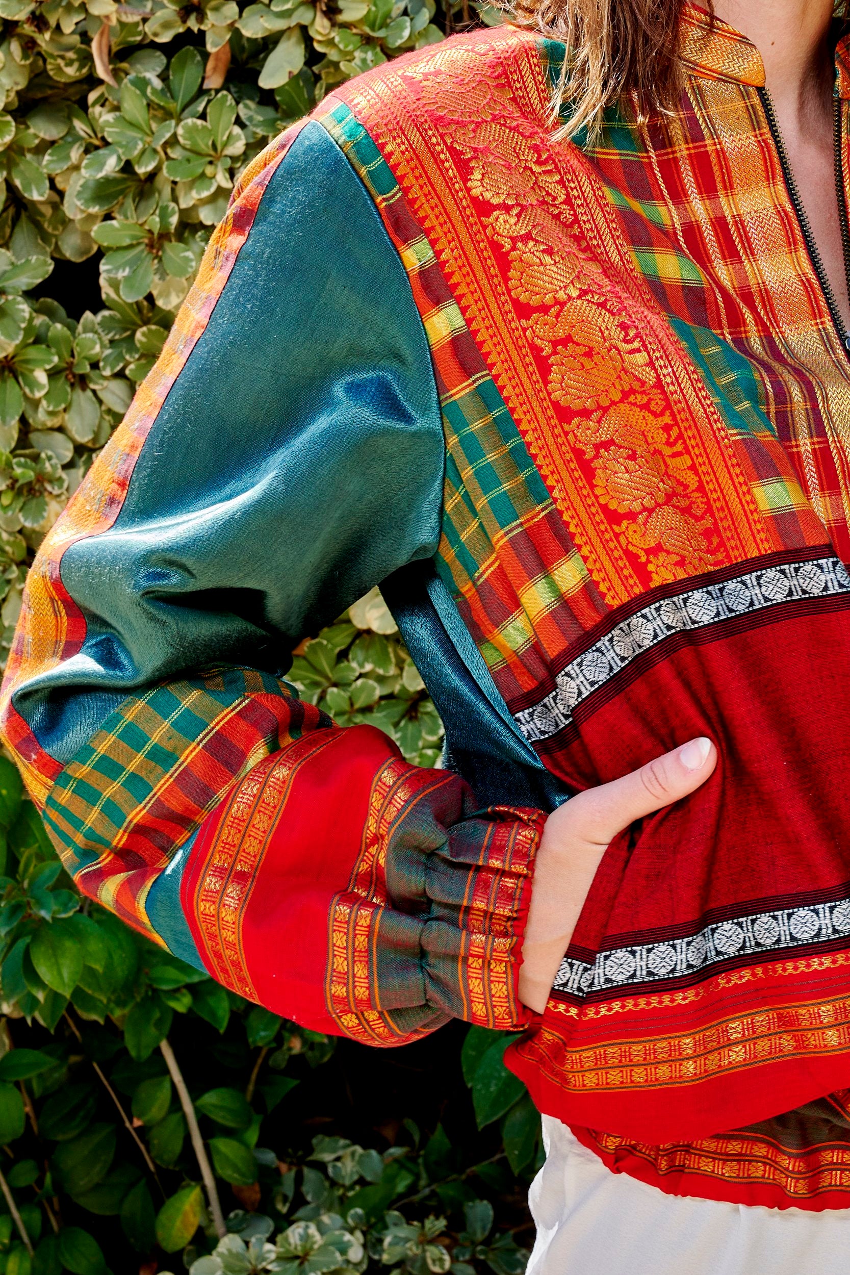 Model wearing a handmade bomber jacket made from repurposed precious fabric.