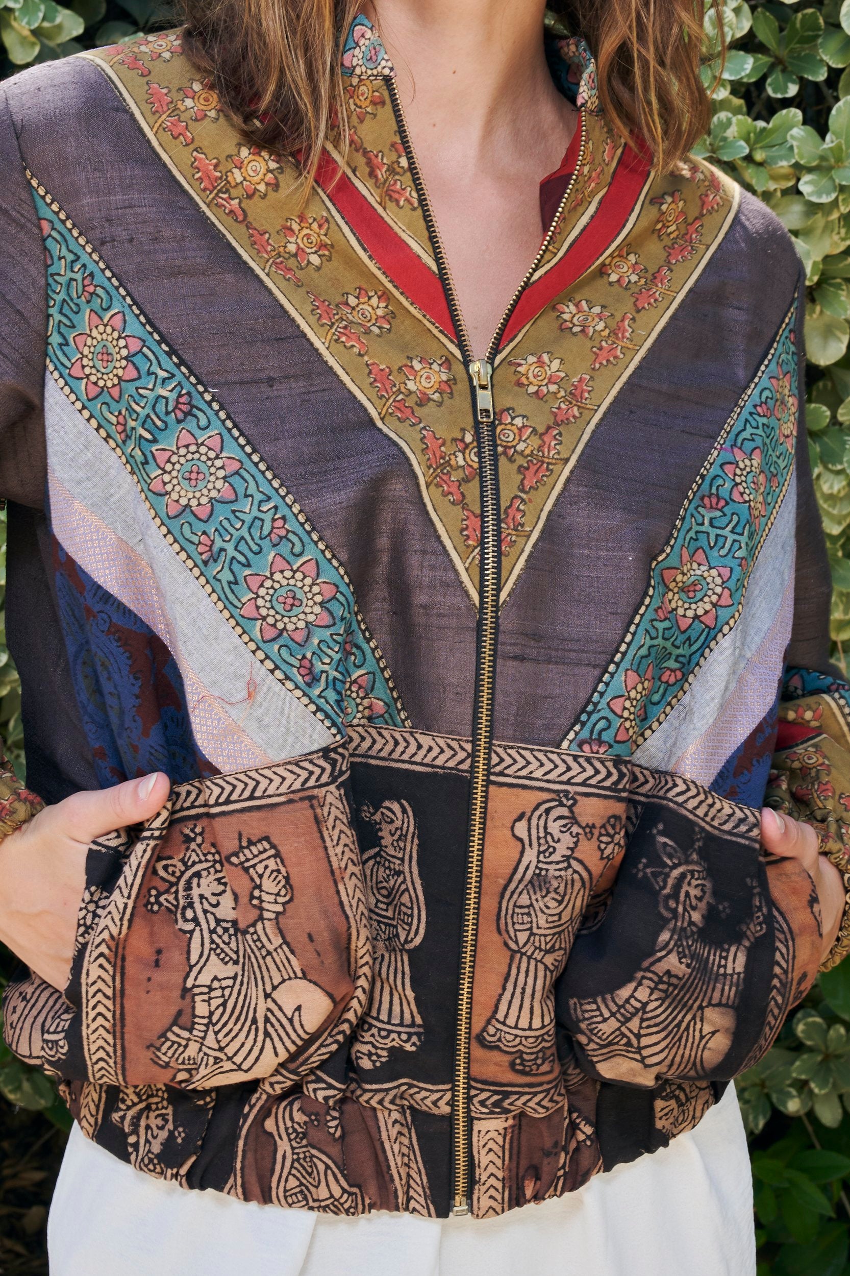 closeup shot of a bomber jacket showing details of the fabric and artwork on the jacket.