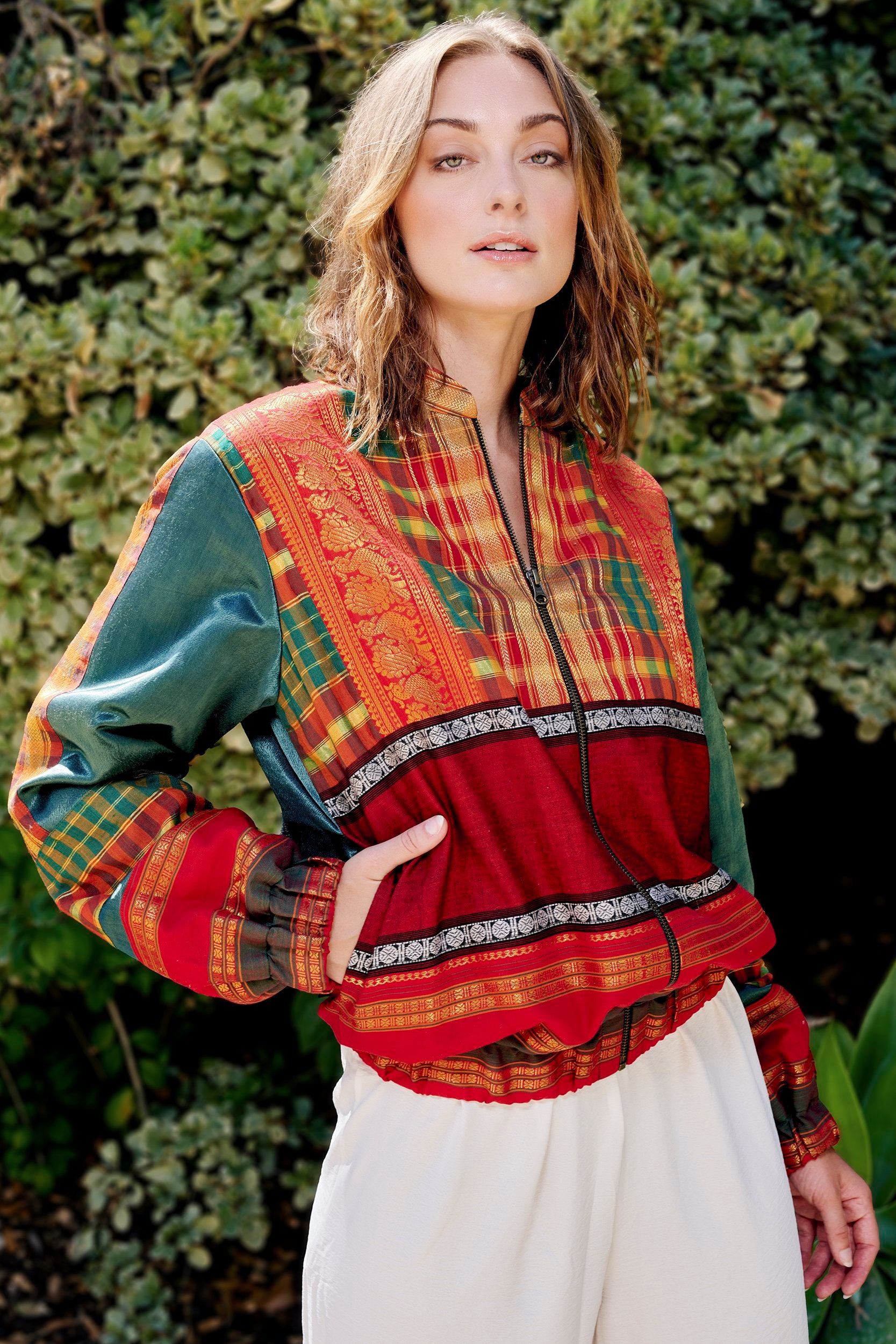 Model wearing a handmade bomber jacket, created from repurposed precious fabric remnants.