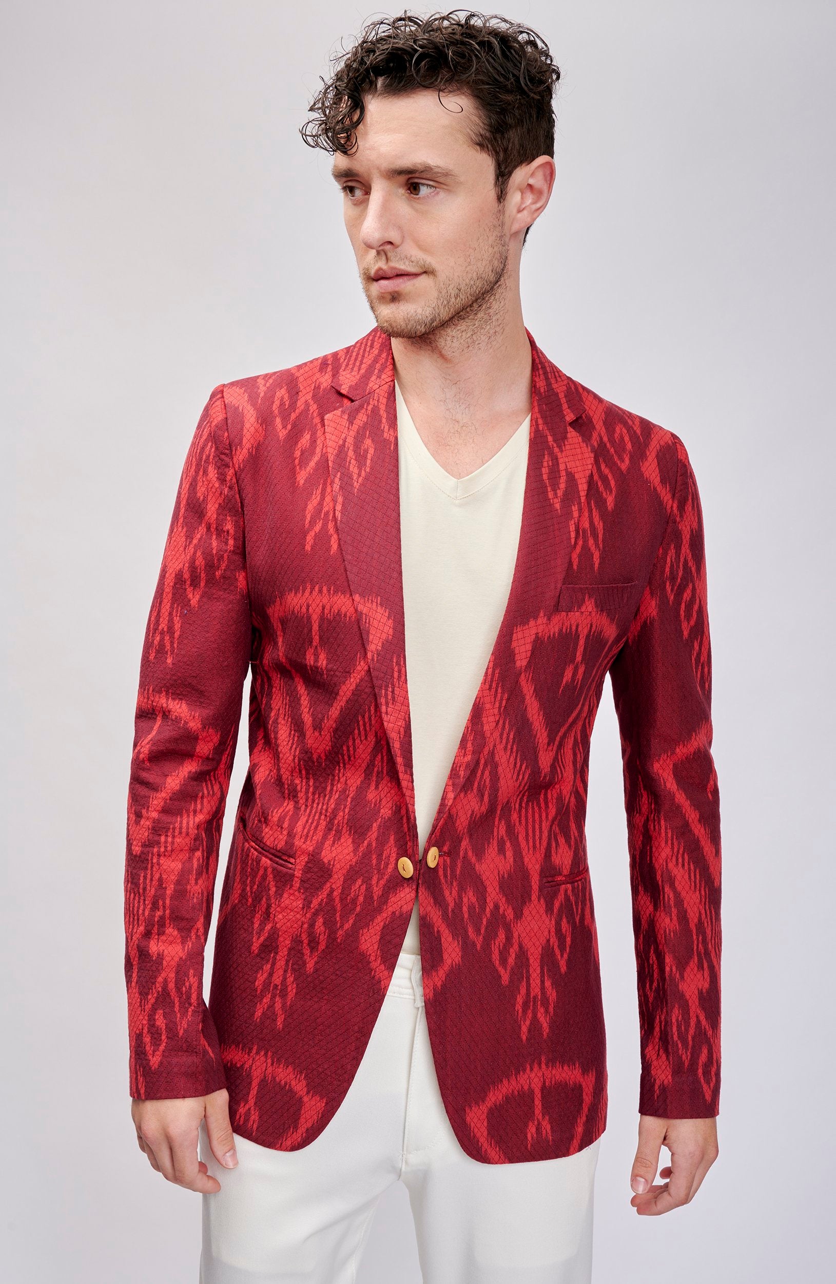 Model wearing a crimson on-tone blazer with a bold pattern. Hand woven and hand stitched.