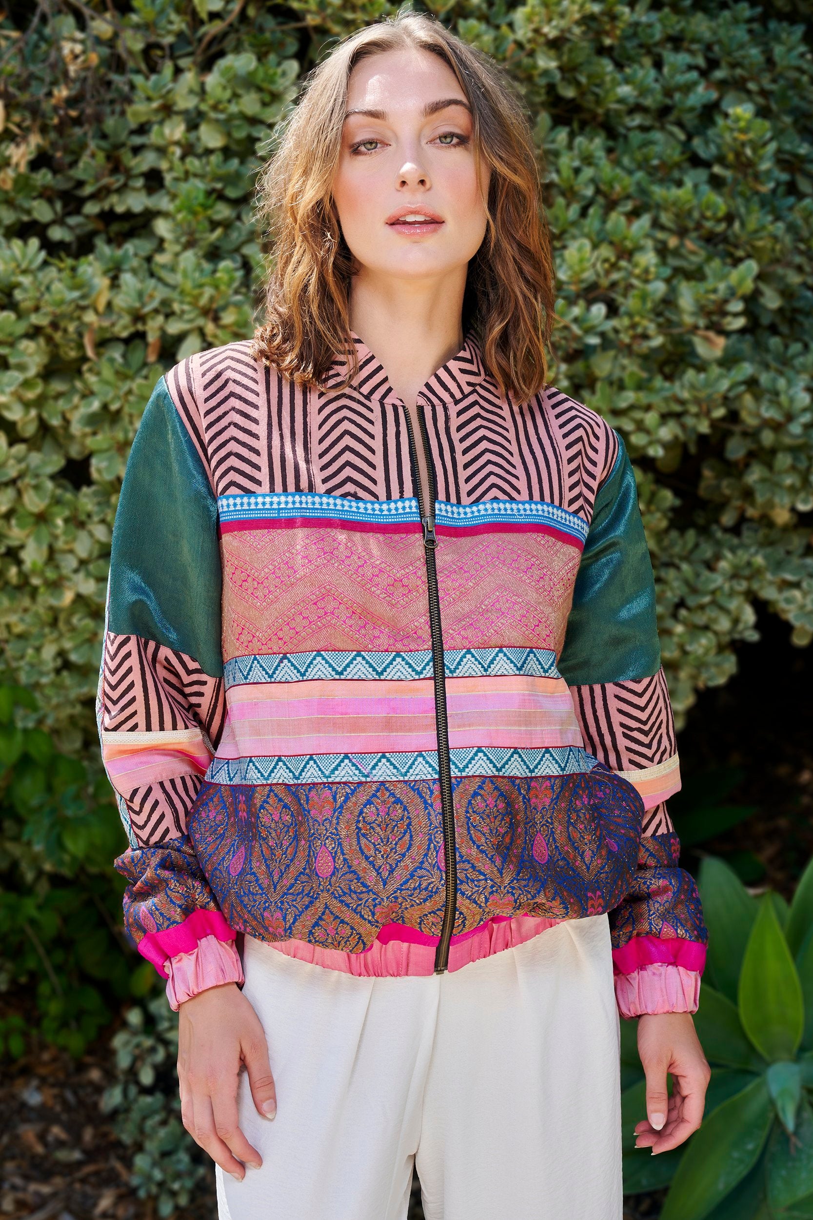 A woman wearing a pink color patterned handmade Bomber Jacket. Sustainably crafted by artisans in India.