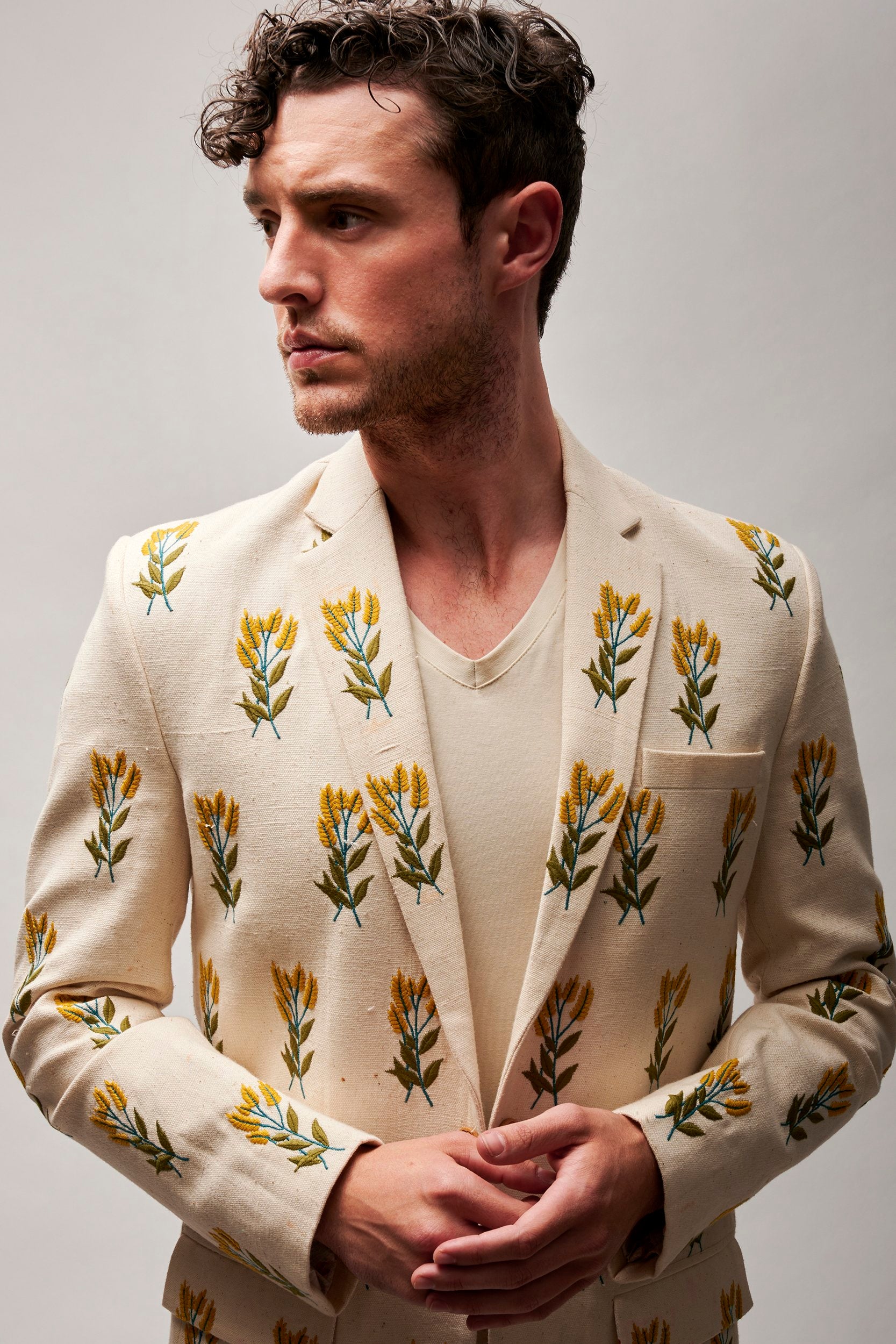 A model wearing a hand embroidered blazer made with organic cotton. Handwoven and hand-stitched, creating a distinctive and eco-friendly fashion piece.