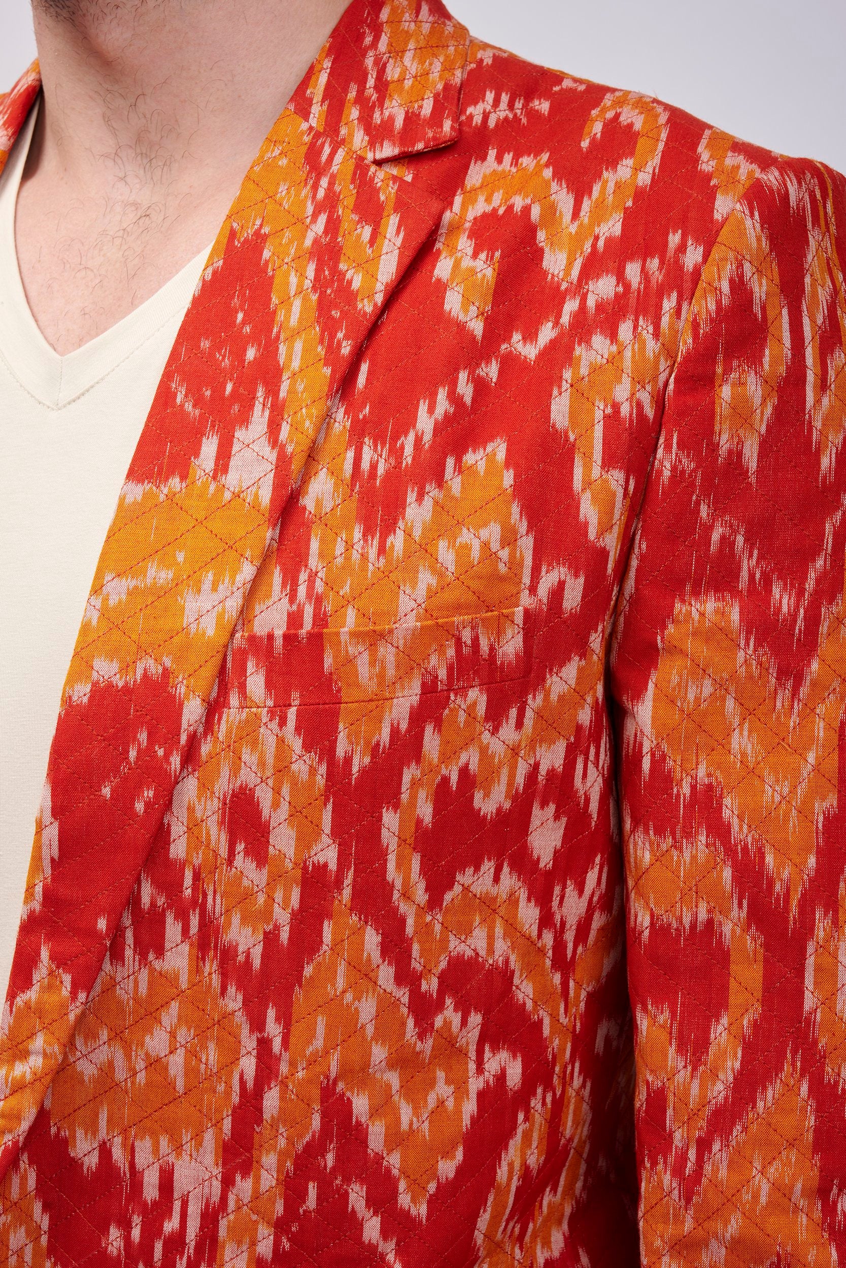 closeup shot of a blazer showing it's rich yellow and orange hues with cross stitch lines on the surface.