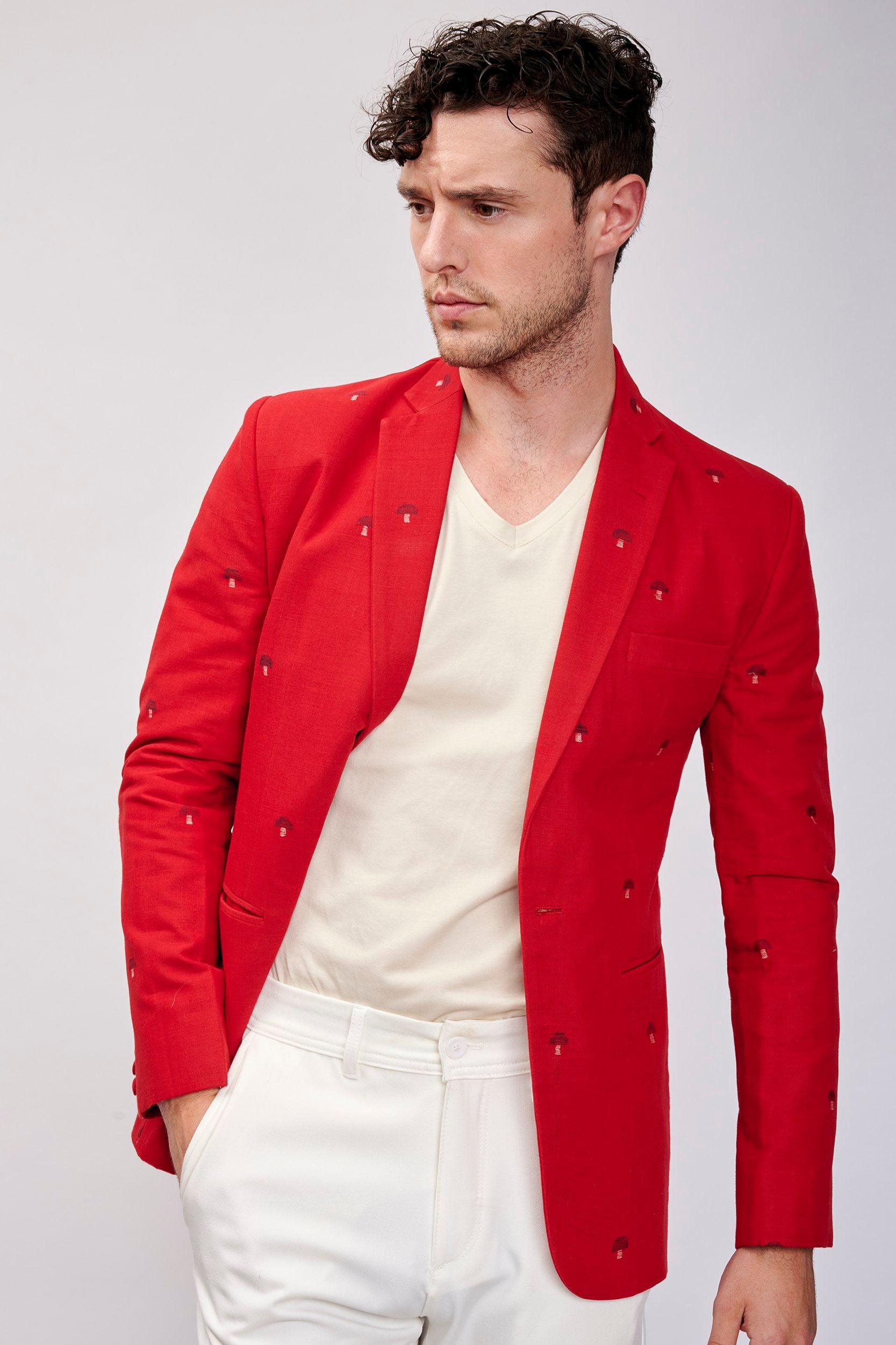 Model wearing a red blazer. Beautifully hand-stitched and embellished with carved wooden buttons.