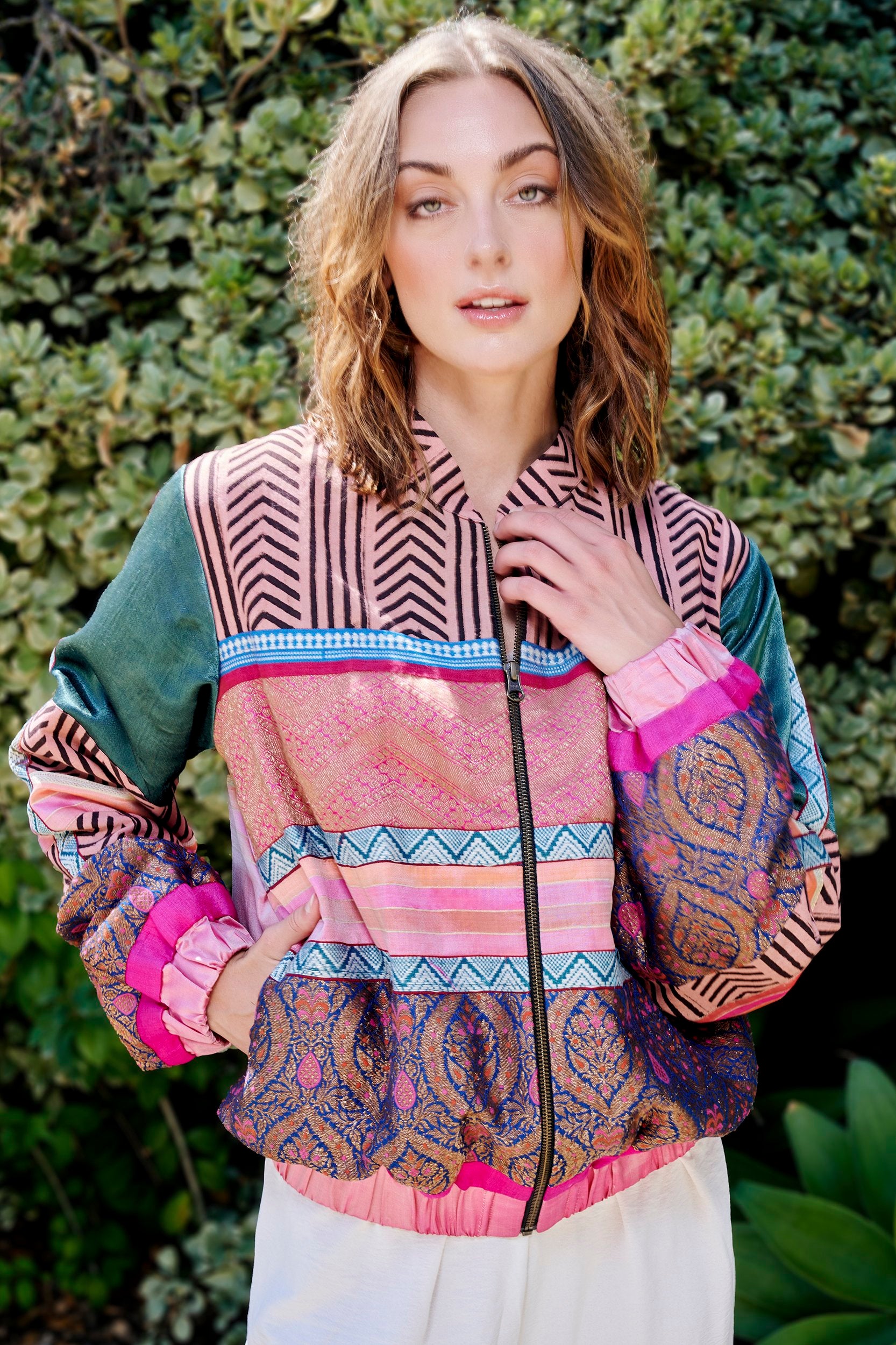 A woman wearing a pink color patterned handmade Bomber Jacket.