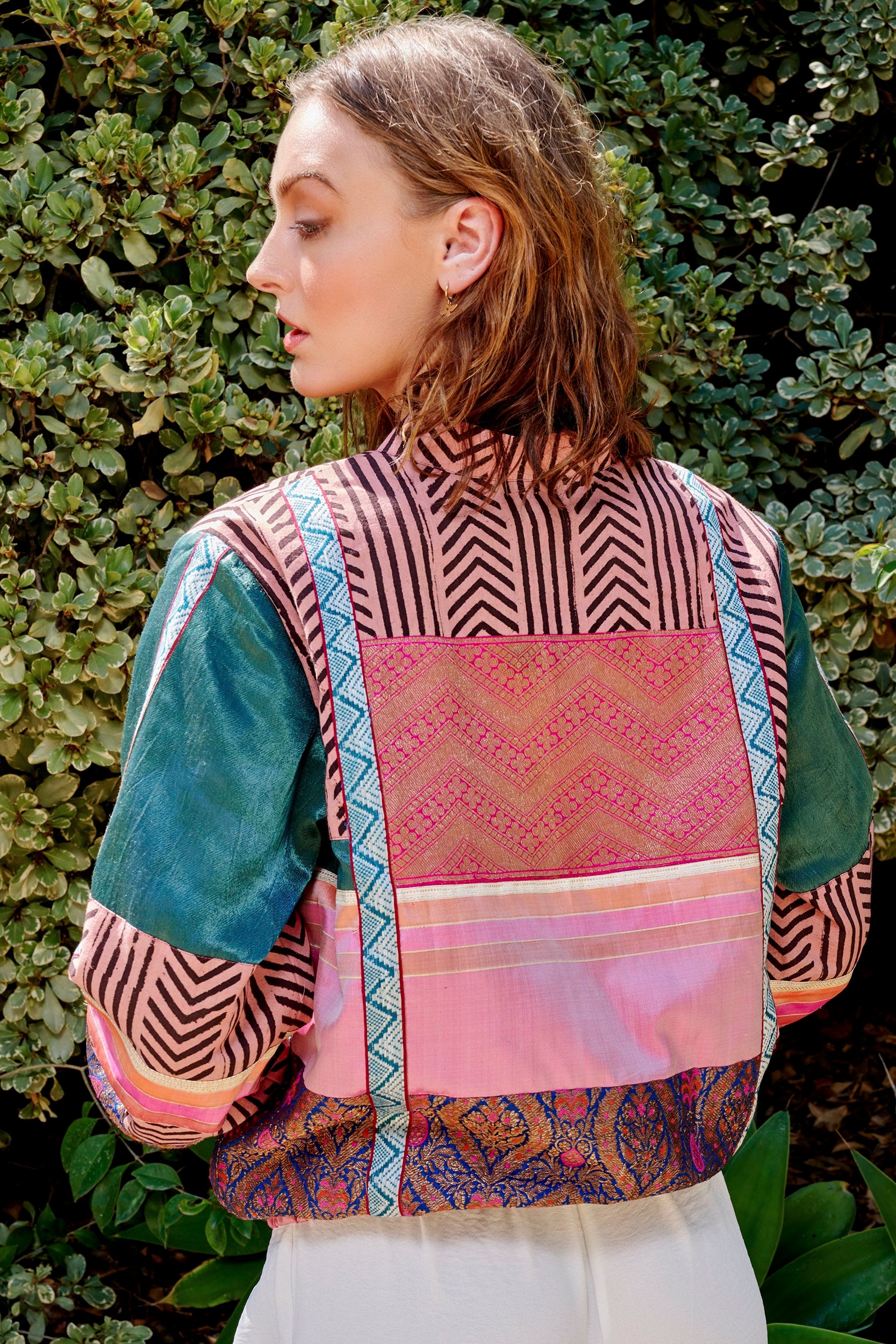 Model wearing a Pink Bomber Jacket showcasing weaves and prints from various parts of India. Sustainably crafted by artisans.
