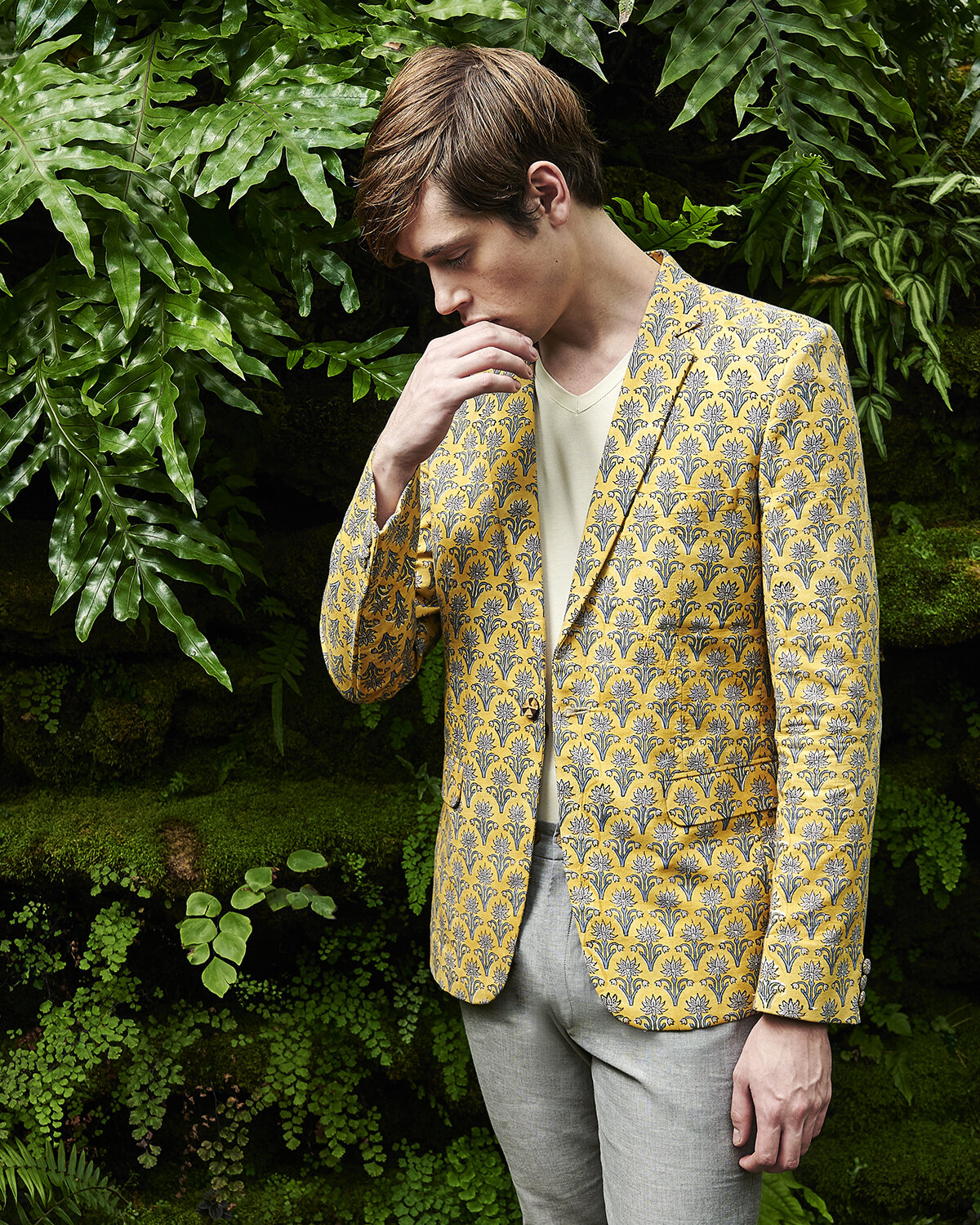 Model wearing a sustainable blazer made with Turmeric-dye. It is hand-block printed with motifs of open flowers.