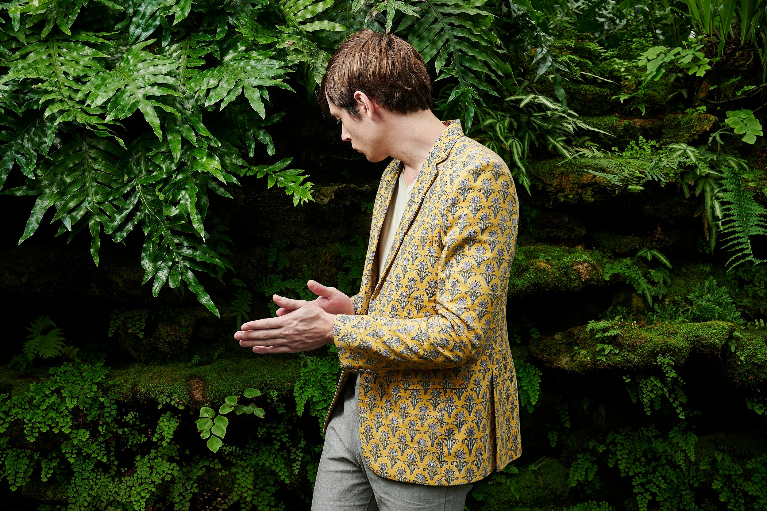Model wearing a sustainable jacket made with Turmeric-dye. It is hand-block printed with motifs of open flowers.