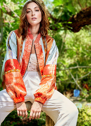 girl wearing a ivory and gold bomber jacket